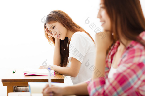 沮丧的女学生在教室里的 studiyng