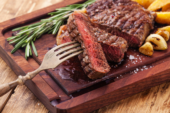 烤的牛肉牛排眼扒配烤土豆切成薄片 切牛肉