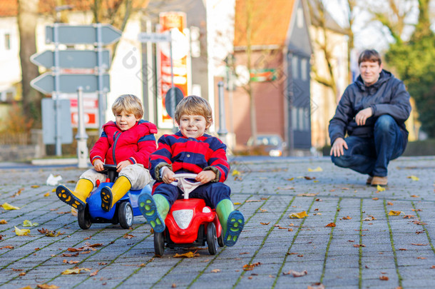 Two <strong>happy</strong> sibling boys and father playing with big old toy car, 