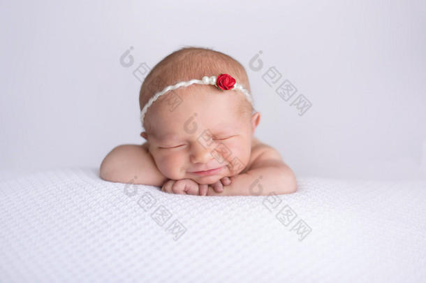 微笑着刚出生的婴儿<strong>女孩</strong>穿着红色的<strong>玫瑰</strong>头带