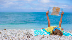 可爱的小女孩，用地图找到热带海滩度假