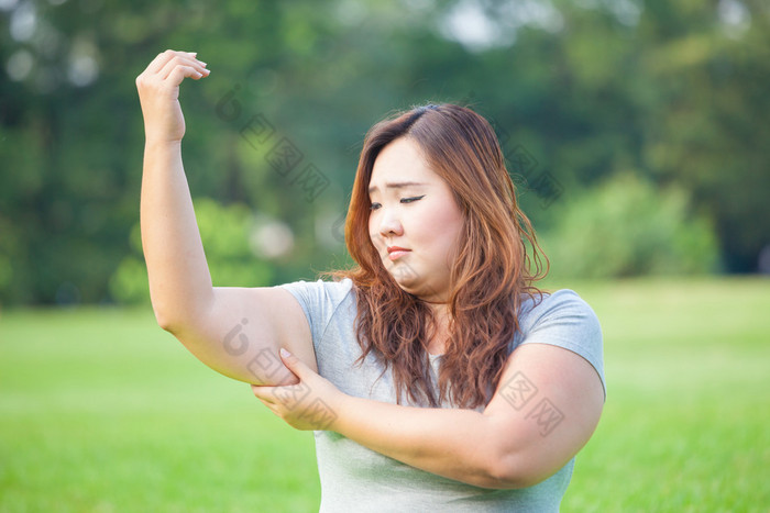 检查她的手臂胖的年轻女子