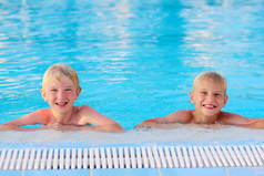 两个男孩在夏天游泳池玩