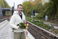 男子在火车站与鲜花等