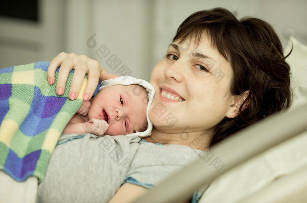 happy woman after birth with a newborn baby