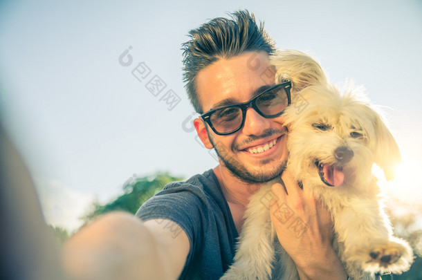 年轻男子和他的狗采取自拍照