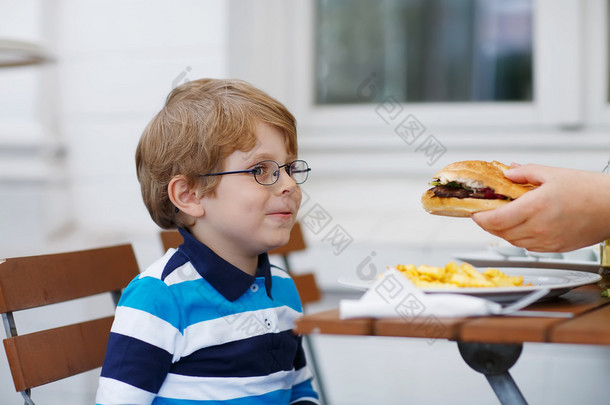 小男孩吃快餐： <strong>法式炸薯条</strong>和汉堡