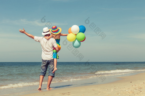 <strong>父亲</strong>和<strong>女儿</strong>用 da 在沙滩上玩耍的气球