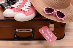 手提箱和旅游的东西与木制背景题字旅游保险