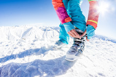女子滑雪运动员紧固她的靴子