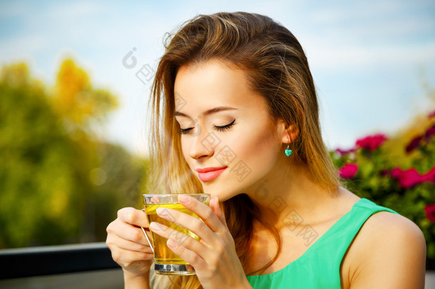 年轻女人喝绿茶户外