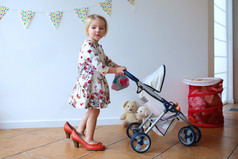 可爱的小女孩玩玩具婴儿车和娃娃
