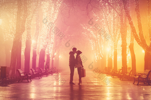 夫妇与行李箱接吻在夜晚小巷.