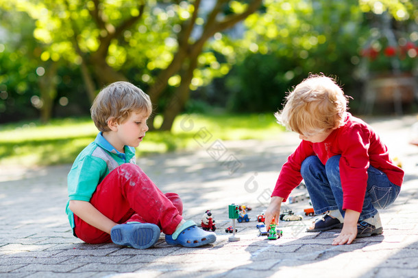 两个小家伙男孩在玩玩具车
