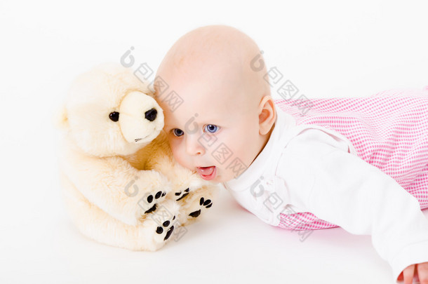 蓝眼睛的婴儿用一个软的玩具。工作室照片