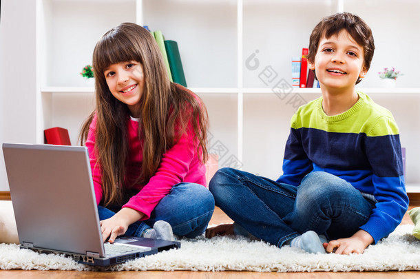 可爱的<strong>小</strong>女孩和<strong>小男孩</strong>使用的笔记本电脑