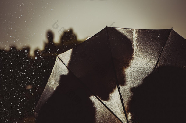 雨中的爱情/雨伞下亲吻情侣的轮廓
