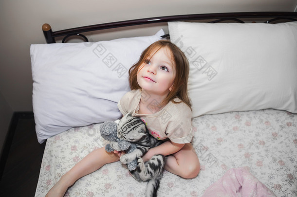 小女孩在床上玩一只小猫
