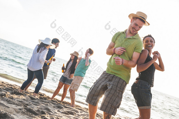 多种族集团的朋友们在海滩上开一个晚会