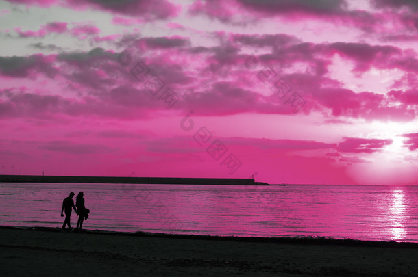 在海边散步，一对年轻夫妇的剪影