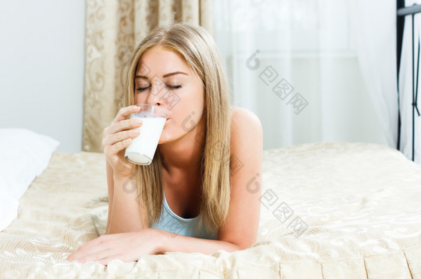 女人是<strong>躺在</strong>她<strong>床上</strong>，喝牛奶