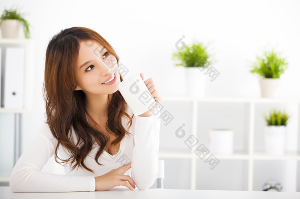 幸福的亚洲年轻女人喝咖啡