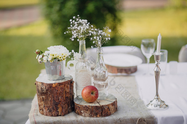 野生<strong>花卉</strong>在玻璃瓶和金属桶上节日的餐桌，婚礼表