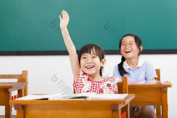 在类的快乐的学校孩子们举手