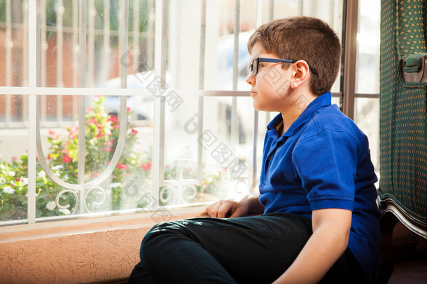 小男孩坐在窗前