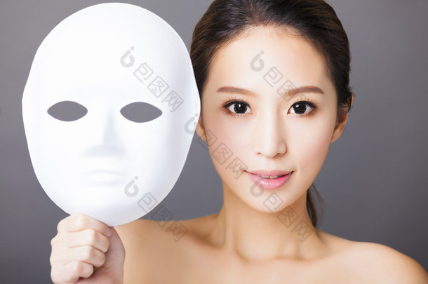 年轻女子捧着白色面具的医疗美容概念
