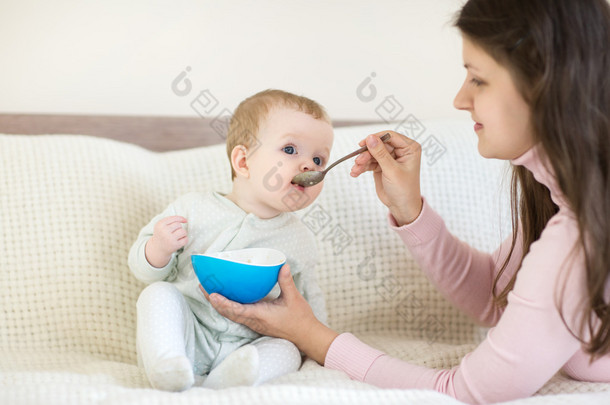 吃饭时坐在床上的婴儿