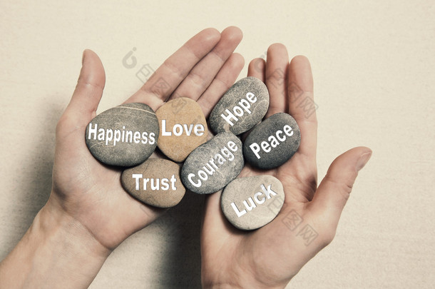 内心的平衡概念: 手里拿着的石头与单词快乐
