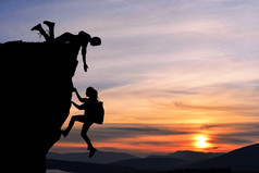 两人男人和女孩旅行联合工作团队在登山团队，美丽的日落景观互相帮助.