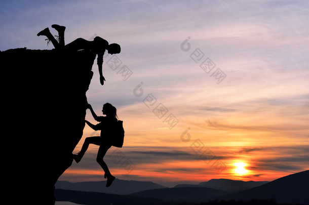 两人男人和女孩旅行联合工作团队在登山团队，美丽的日落景观互相帮助.