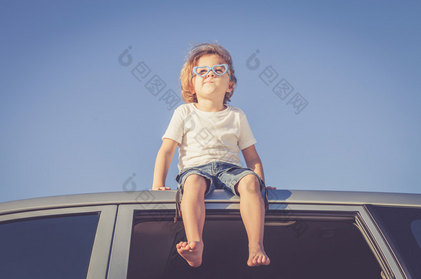 快乐的小男孩坐在车里
