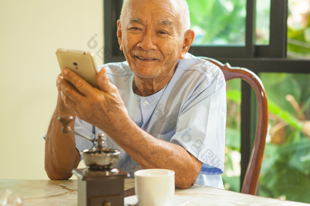 在家里使用移动电话的快乐亚洲高级人