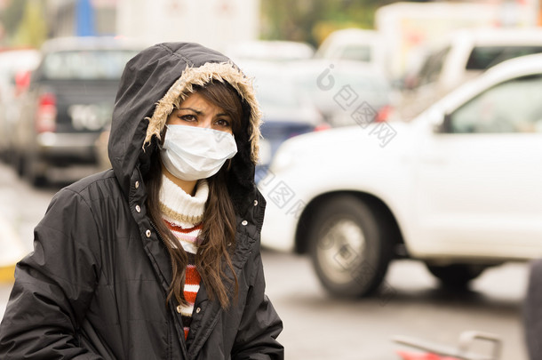 年轻女孩步行穿上衣和掩码中污染的城市街道概念