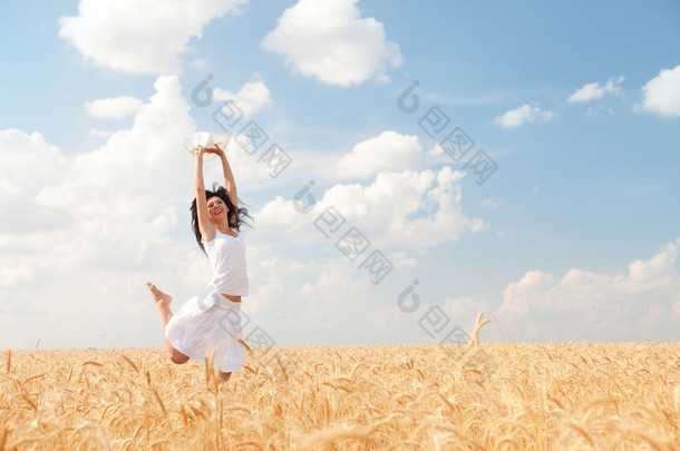 <strong>快乐</strong>的女人跳在金黄小麦