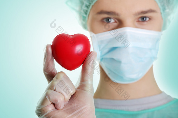 läkaren håller hjärta form leksak