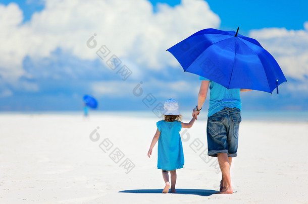 父亲和女儿在海滩散步