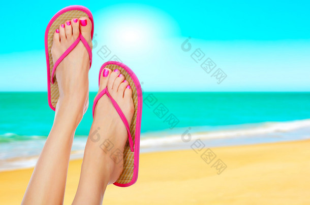 在女人的腿上的粉色凉鞋。夏季时间概念
