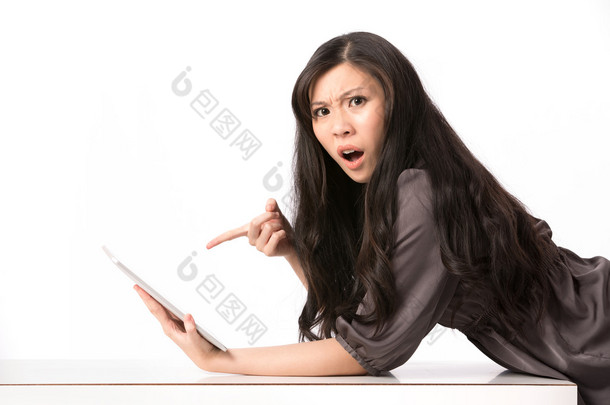 震惊的<strong>女子</strong>指着她的数码平板电脑.