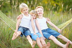 三个孩子在夏天的草地上玩耍
