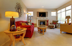 优雅的客厅与红色的沙发、 壁炉、 电视和许多 windows.