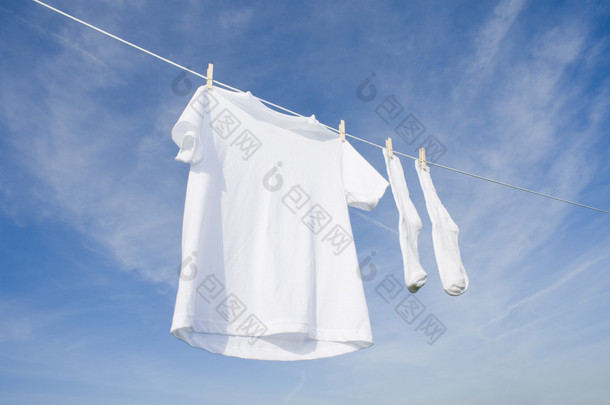 白色 t 恤和袜子在蓝蓝的天空上