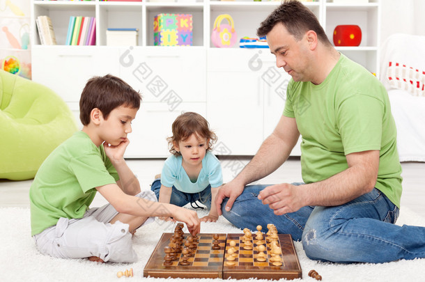 男孩和他们的<strong>父亲</strong>下棋
