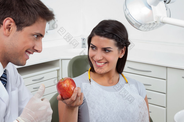 牙医给持有 ap 一女病人看标志竖起大拇指