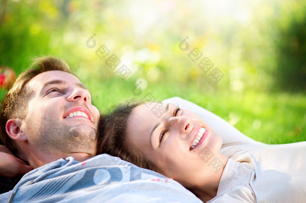 躺在户外草地上的年轻夫妇