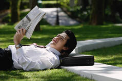一个男人躺了下来，读报纸