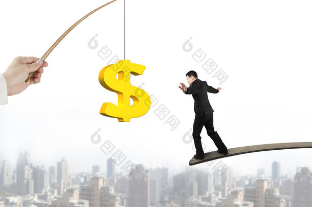 Man balancing golden dollar sign fishing lure with cityscape